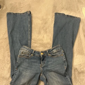 Blå jeans från Vero Moda - Snygga blå jeans från Vero Moda med klassisk femficksdesign och knappgylf. Jeansen har en bootcut-stil som ger en retro känsla. Perfekta för en avslappnad look. Bra skick. Strl S, midjemått 37, bra längd på mig som är 1.60 1.61