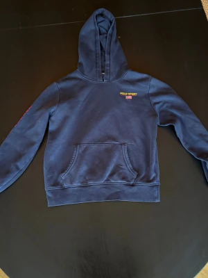 Mörkblå Polo sport/Ralph Lauren Hoodie Strlk 14-16 år  - Säljer mörkblå polo sport/Polo Ralph Lauren hoodie i storlek 14-16 år men är liten i storleken. Den är använd utan några verkliga deffekter. 