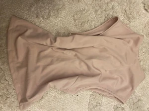 Ljusrosa långkjol med fickdetaljer och topp - Säljer en ljusrosa långkjol med snygga fickdetaljer framtill och bälteshällor i midjan. Kjolen har en rak siluett och en slits framtill för extra rörelsefrihet. Materialet känns mjukt och har en lätt stretch, perfekt för en clean och chic look.