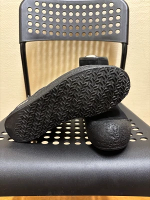 Svarta mockaboots från Bally - Säljer ett par svarta boots från Bally i mjuk mocka med grov gummisula och rund tå. Skorna har dragkedja baktill för enkel på- och avtagning. Diskret Bally-logga på sidan och sula. Perfekt för dig som gillar stilrena och robusta skor.