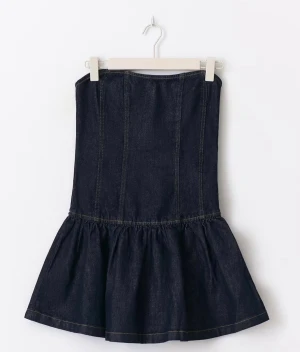 Mörkblå jeansklänning med volang  - Säljer en mörkblå jeansklänning från Ginatricot i storlek S. Klänningen är helt ny med prislapp kvar, aldrig använd. Perfekt för dig som gillar denim och vill sticka ut med en kort och snygg klänning. Nypris 499