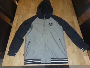 Jr Vinterjacka / Skidjacka från Burton Strl XL (160/72) - -Vindtät och vattentät med tejpade sömmar -Thermacore™-isolering som håller kylan ute -DRYRIDE™-membran som ger god luftcirkulation -Taftfoder med bakpanel i microfleece -Fulltime Contour™-huva med damask anpassad för hjälm -Bekvämt hakskydd som inte skaver -Neddragbar Contour™-huva anpassad för hjälm, utrustad med huvdamask -Snölås i midjan och fäste mellan jacka och byxa -Handvärmarfickor med fleece, innerficka för liftkort -Room-To-Grow™-system gör att ärmarna kan förlängas  