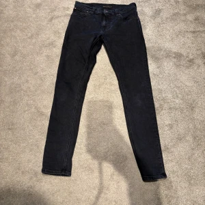 Nudie jeans - Svarta jeans från nudie. Jeansen har smal passform, normal midja och är tillverkade i stretchig bomull för en bekväm känsla. Perfekta för dig som gillar en stilren och enkel look. Skick 8/10 pris går att diskuteras 