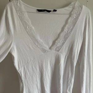 Vit långärmad topp med spets - långärmad spetstopp från Vero Moda i strl XS men är lite stor i v ringningen. Använd några gånger