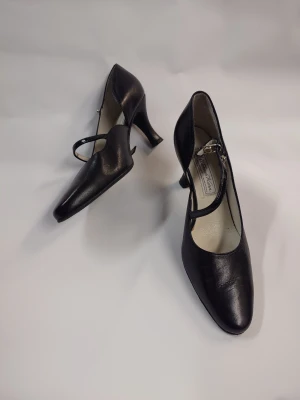 Svarta pumps med klack och rem - Snygga svarta Dansskor från Werner kern med elegant klack och smal rem över foten. Skorna har en rund tå och är tillverkade i skinn som ger en klassisk och stilren look. Perfekta för dig som gillar en tidlös och chic stil. Nypris 1500-1800kr