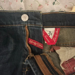 Lucky brand jeans - Blà jeans frän lucky brand med sa snygga detaljer, bland annat den ikoniska dragkedjan! | perfekt skick. Längd 93cm Innerbenslängd 69cm