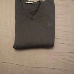  tröja Sail Racing S - Svart v-ringad tröja från Sail Racing i storlek S. Tröjan har diskret logga broderad på bröstet och ribbade muddar vid halsen. Materialet är mjukt och stickat, perfekt för dig som gillar stilrena och enkla plagg.