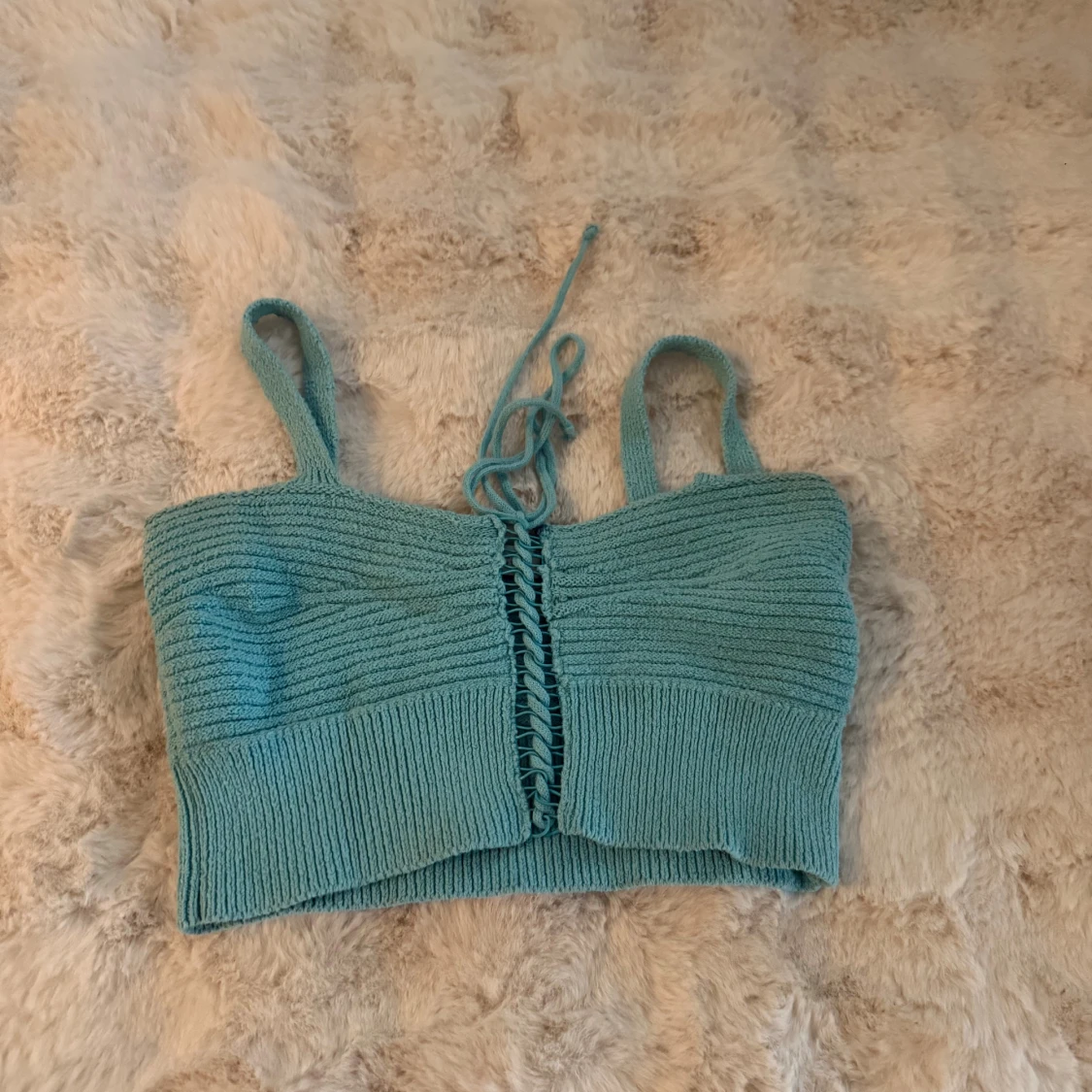 Turkos stickad linnetopp med snörning