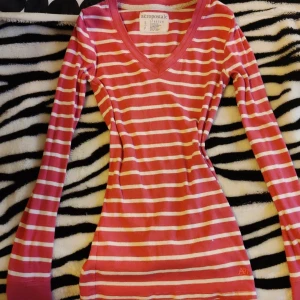 Randig rosa långärmad tröja Aeropostale - Snygg långärmad tröja från Aeropostale i rosa och vita ränder. Tröjan har v-ringad hals och figurnära passform. Materialet är en stretchig mix av bomull och polyester med lite spandex för extra komfort. Perfekt för dig som gillar en enkel men färgglad stil.💕