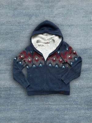 Stickad Hollister hoodie - En stickad Hollister zip-hoodie med snyggt mönster. Tröjan har även otroligt skön fodring! 