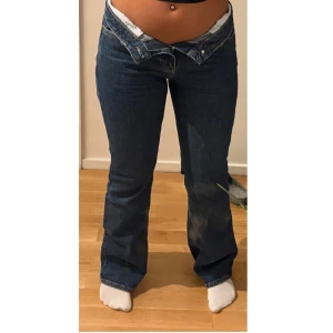 Levis 501 lågmidjade bootcut jeans - Mörkblå Levis 501 jeans med låg midja och bootcut-ben. Klassisk femficksmodell i jeansmaterial med raka sömmar och snygg passform. Perfekta för dig som gillar en avslappnad och trendig look.