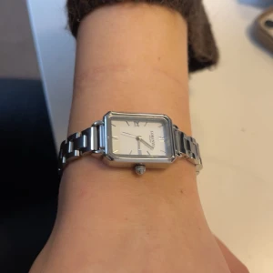 Silverfärgad klocka - Stilren klocka med märket Lorenzo Milano. jättesnygg. Går att ta av delar för att få den mindre och även sätta dit delar för att få den större. 