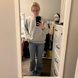 Ljusblå bootcut jeans - Säljer ett par ljusblå jeans med bootcut passform och normal midja. Klassisk femficksmodell med dragkedja och knapp framtill. Jeansen har en snygg, enkel look och är tillverkade i mjukt denimtyg som sitter skönt på kroppen.