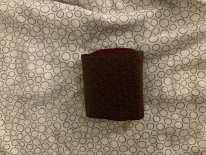 Brun plånbok med mönster och dragkedja - Snygg brun plånbok med diskret geometriskt mönster och guldfärgad dragkedja. Kompakt och praktisk design med plats för kort och mynt. Perfekt att ha i väskan eller fickan för att hålla ordning på dina grejer.