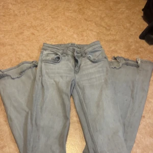 Ljusgrå bootcut jeans  - Säljer ett par ljusgrå jeans med bootcut passform och slitna detaljer vid bensluten. Dom är använde men färgen finns inte att köpa längre men priset går att prata om dom är från lager 157 Storlek XXS FULL LENGHT