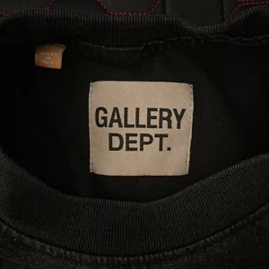 Svart sweatshirt från Gallery Dept. - Svart sweatshirt från Gallery Dept. med grönt tryck på bröstet och ryggen där det står 'GALLERY DEPT. HOLLYWOOD, CA.'. Rund hals och mjukt material, perfekt för dig som gillar streetwear och vill sticka ut med en fet logga.