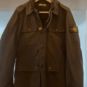  Stone Island jacka  - Säljer denna väldigt sällsynta Stone island jacka i storlek S! Klassiska patchen på vänster ärm. Jackan har fyra stora fickor framtill, både med knapp och dragkedja, samt krage och långa ärmar. Perfekt för dig som vill gå med klass och vill ha en extra clean look inför vintern. Köpte för 2499 men säljer nu för 1499! 