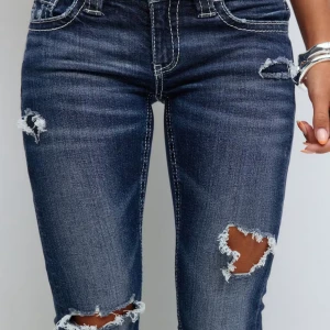 Blå bootcut jeans med slitningar - Snygga mörkblå Bootcut jeans som är lågmidjade med slitna detaljer. Baksidan har dekorativa broderade fickor. Perfekta för dig som gillar en trendig look.  Men har hålen har  blivit  lite större kan skicka fler bilder på den 💕💕