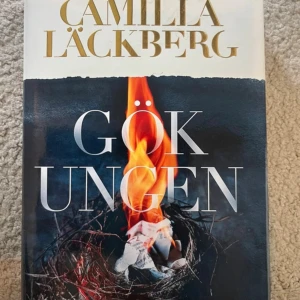 Gökungen - En spännande bok av Camilla Läckberg med ett omslag som visar en brinnande fågelunge i ett bo. Perfekt för dig som gillar mysterier och vill ha något riktigt fängslande att läsa.