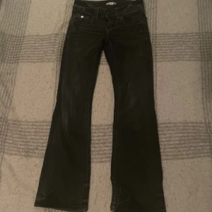 Svarta bootcut jeans från Gina Tricot - Snygga low waist svarta jeans från Gina Tricot i storlek 152. Modellen har klassisk femficksdesign, markerade sömmar och bootcut-ben som ger en schysst siluett. Perfekta för dig som gillar en tidlös look med lite extra edge.
