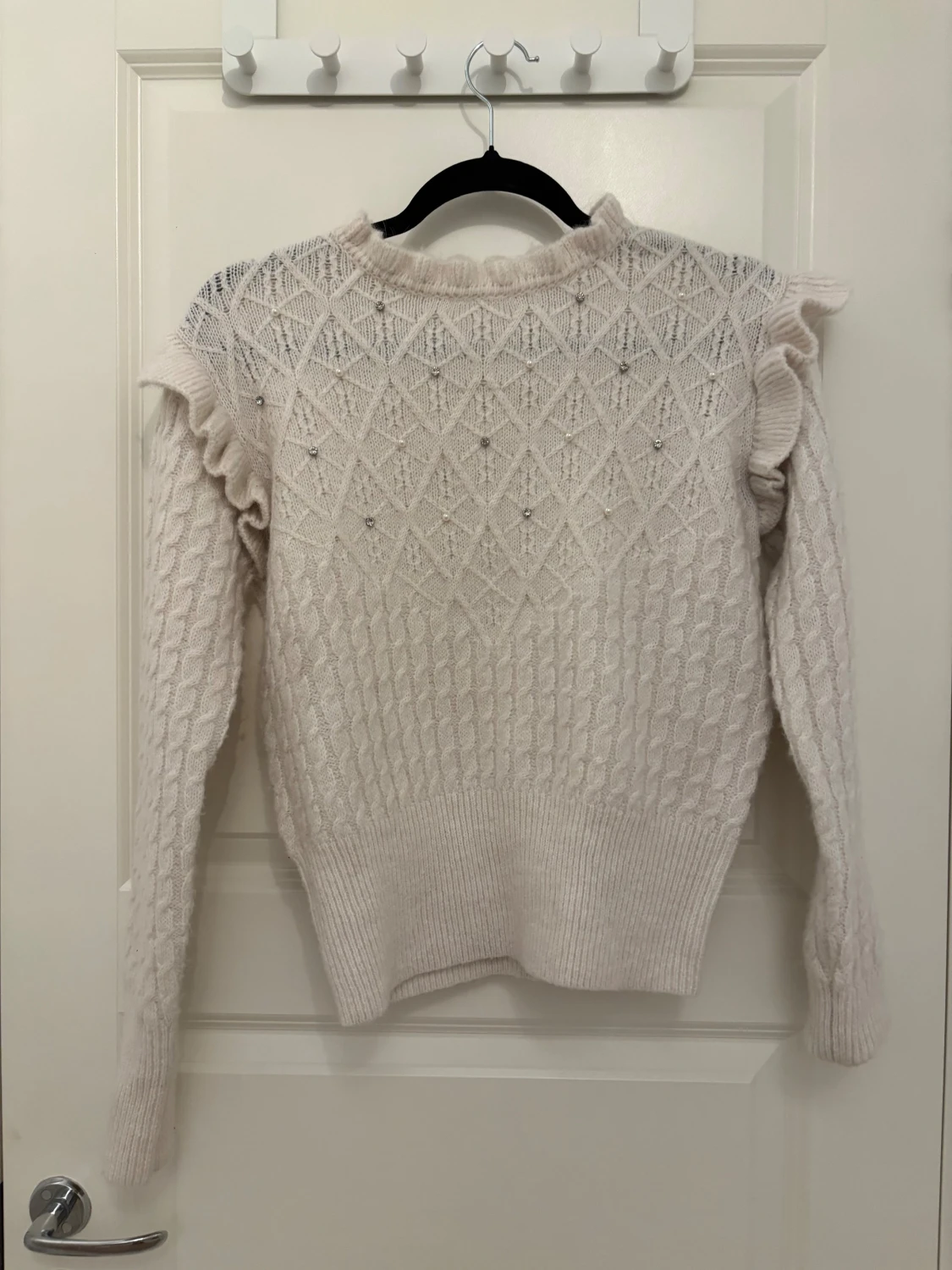 Vit stickad tröja med pärlor och volang