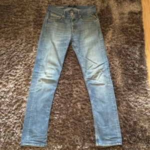 Replay Anbass ljusblå jeans regular fit - Snygga ljusblå Replay Anbass jeans med regular fit och klassisk femficksdesign. Jeansen har en lätt tvättad look, normal midja och raka ben. Materialet är mjukt jeans med stretch för extra komfort. Perfekt för dig som gillar stilrena och moderna jeans. Storleken är W30 och L32