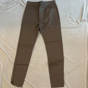 Beiga skinny byxor från Stradivarius - Snygga beiga byxor från Stradivarius i storlek 40. Modellen är skinny med klassisk femficksdesign och normalhög midja. Byxorna är tillverkade i ett stretchigt material som sitter tajt och bekvämt. Perfekta för en clean och stilren look.