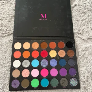 Morphe Nikita ögonskuggspalett - Färgstark ögonskuggspalett från Morphe x Nikita med 35 nyanser i både matta och skimrande toner. Paletten innehåller allt från neutrala bruna och guldiga färger till intensiva blå, lila, rosa och gröna nyanser. Perfekt för kreativa och uttrycksfulla sminkningar. Paletten är använda några gånger men det är många färger som är helt orörda. 