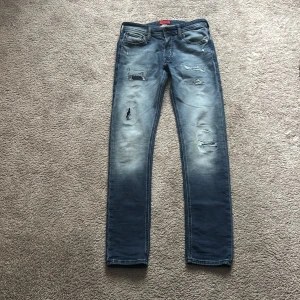 Slim Glenn jeans från Jack & Jones - Snygga blå jeans från Jack & Jones, modell Slim Glenn. De har slitna detaljer. 