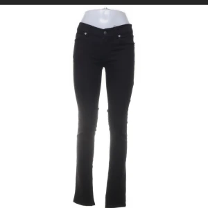 Svarta bootcut jeans 29/34 - Svarta jeans med bootcut passform och klassisk femficksdesign. Snyggt smal passform upptill som går ut i lätt utsvängda ben. Jeansen har normal midja och är tillverkade i ett stretchigt bomullsmaterial för extra komfort.