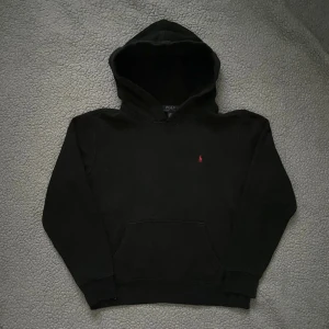 Svart hoodie från Polo Ralph Lauren - Svart hoodie från Polo Ralph Lauren med klassisk röd broderad logga på bröstet👕 bra skick, inga hål eller liknande men något urtvättad✅ skickar snabbt efter att du har beställt📦