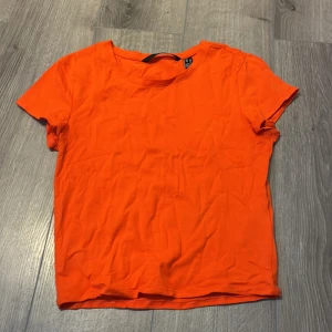 Orange t-shirt från Vero Moda XS - En enkel och snygg orange t-shirt från Vero Moda i storlek XS. T-shirten har rund halsringning och korta ärmar. Perfekt för dig som gillar färgstarka basplagg. 
