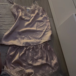 Ljuslila satinlinne med spetsdetaljer - Oanvänt pyjamassätt från H&M. Använder inte.