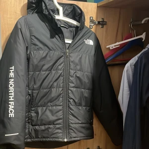 Svart pufferjacka från The North Face (14-16) - Säljer en nortface jacka i mycket bra skick (9/10). Den har bara används vid fåtal tillfällen och är perfekt nu till hösten. Jag är 165 och den passar mig perfekt. Tveka inte om att kontakta vid intresse!