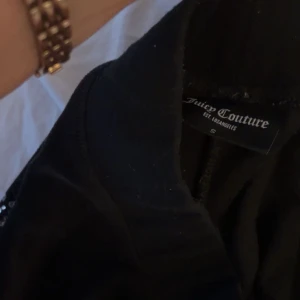 Svarta velourbyxor Juicy Couture S - Svarta mjukisbyxor från Juicy Couture ingen snörning tyvär.  Byxorna har raka ben och klassisk Juicy-logga i strass på baksidan. Perfekta för en chill och trendig look.