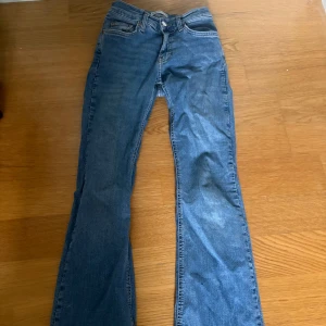 Blå bootcut jeans från Gina tricot - Snygga blå jeans från Gina tricot i klassisk bootcut-modell. Jeansen har fem fickor, normal passform och är tillverkade i mjukt denimtyg. Perfekta för dig som gillar en tidlös look med lite utsvängda ben.