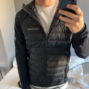 Svart pufferjacka från Peak Performance - Säljer en svart pufferjacka från Peak Performance med quiltad framsida och mjuka ärmar. Jackan har dragkedja framtill, huva och två sidofickor med dragkedja. Köpte ny cirka 3000kr mitt pris 999kr men inte slaget i sten 
