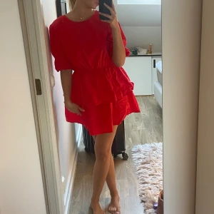 Röd volangklänning med puffärm - Super söt röd klänning med puff armar och kjol. Lite ostruken på bilden 
