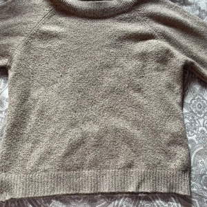 Beige stickad tröja från Vero Moda - Mysig beige stickad tröja från Vero Moda i storlek XS. Tröjan har rund halsringning, långa ärmar och ribbade muddar vid ärmslut och nederkant. Perfekt för lager-på-lager under kyliga dagar.