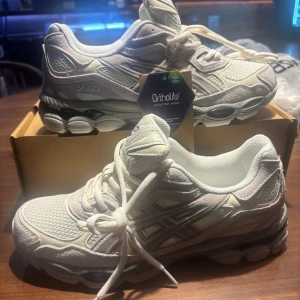 Vita ASICS sneakers strl 43,5 - Säljer ett par fräscha vita ASICS sneakers i storlek 43,5. Skorna har en chunky sula, meshpaneler för extra andningsförmåga och detaljer i syntet och mocka. Klassisk snörning och Ortholite innersula för skön komfort. Perfekta för dig som gillar sportig stil.
