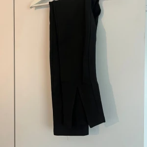 Byxor med slits  - Svarta byxor med slits framtill från nakd i stl xxs.