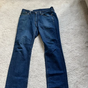 Levi's 514 mörkblå jeans straight fit - Klassiska Levi's 514 jeans i mörkblå denim med raka ben och femficksmodell. Snygga kontrastsömmar, läderpatch bak och röd Levi's-tag på bakfickan. Perfekta för dig som gillar tidlös stil och vill ha ett par jeans som funkar till allt. W:30 L:32