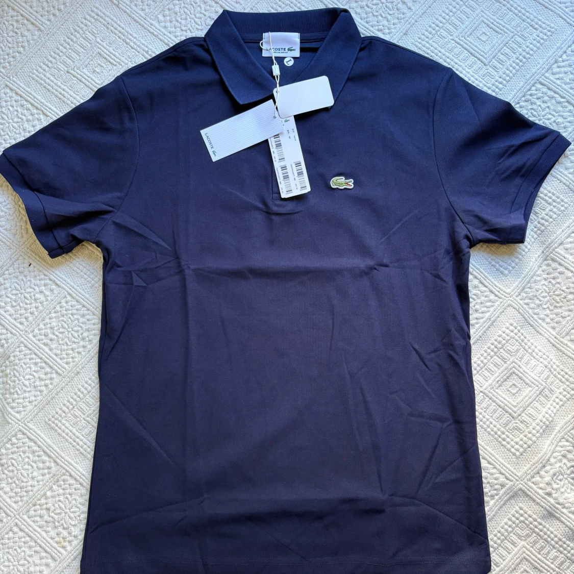 Mörkblå pikétröja från Lacoste