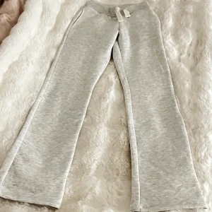 Mjukis byxor från Gina 14+ 💕 - HELT NYA ALLDRIG ANVÄND!!! Superbekväma ljusgrå mjukisbyxor med resår i midjan och snörning. Byxorna har raka ben och två bakfickor med broderad detalj. Perfekta för chill dagar eller när du vill vara extra comfy. Säljer för dom inte passade mig och gå in på Gina 14+ hemsida så kan ni se hur dom ser ut där 💝💝Dom är i tall💓