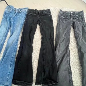 Tre par bootcut jeans i olika färger - Säljer tre par bootcut jeans i blått, svart och grått. Alla har klassisk femficksdesign och snygga detaljer på bakfickorna. Jeansen är i stretchigt denim och har normal passform. Perfekta för dig som gillar en tidlös look med lite utsvängda ben.