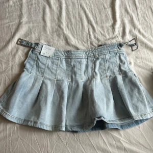 Ljusblå jeanskjol från Mango, strl 38 - Superfin ljusblå jeanskjol från Mango. midjehöjd passform men passar som lågmidjat. Har aldrig använts och priset kan diskuteras💕