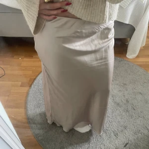 Beige satinkjol  - Säljer en beige skitsnygg långkjol i satinliknande material då den inte kommer till användning 😊😊💗 jättebra skick och inga defekter 
