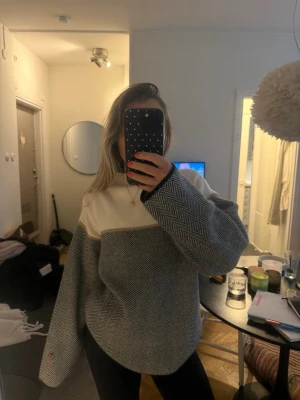 Gråvit stickad tröja från Busnel - Säljer en oversized stickad tröja från Busnel. Tröjan har lång ärm och en liten broderad logga på ärmslutet. Jätte varm och skön! 