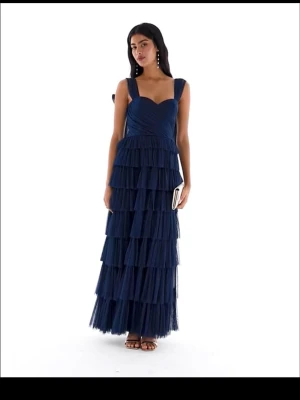 Marinblå volangklänning - Supersnygg långklänning i marinblå tyll med flera lager volanger och  axelband med rosett-detaljer som går att knyta om. Klänningen har hjärtformad urringning och markerad midja. Perfekt för bal eller festliga tillfällen. Endast använd en gång, sista bilden är min egna. Skriv för fler frågor🌸