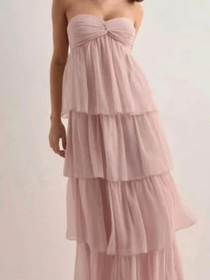 Ljusrosa klänning - Ljusrosa långklänning med volanger och bandeau-topp. Tunt, luftigt material som ger ett drömmigt intryck💞